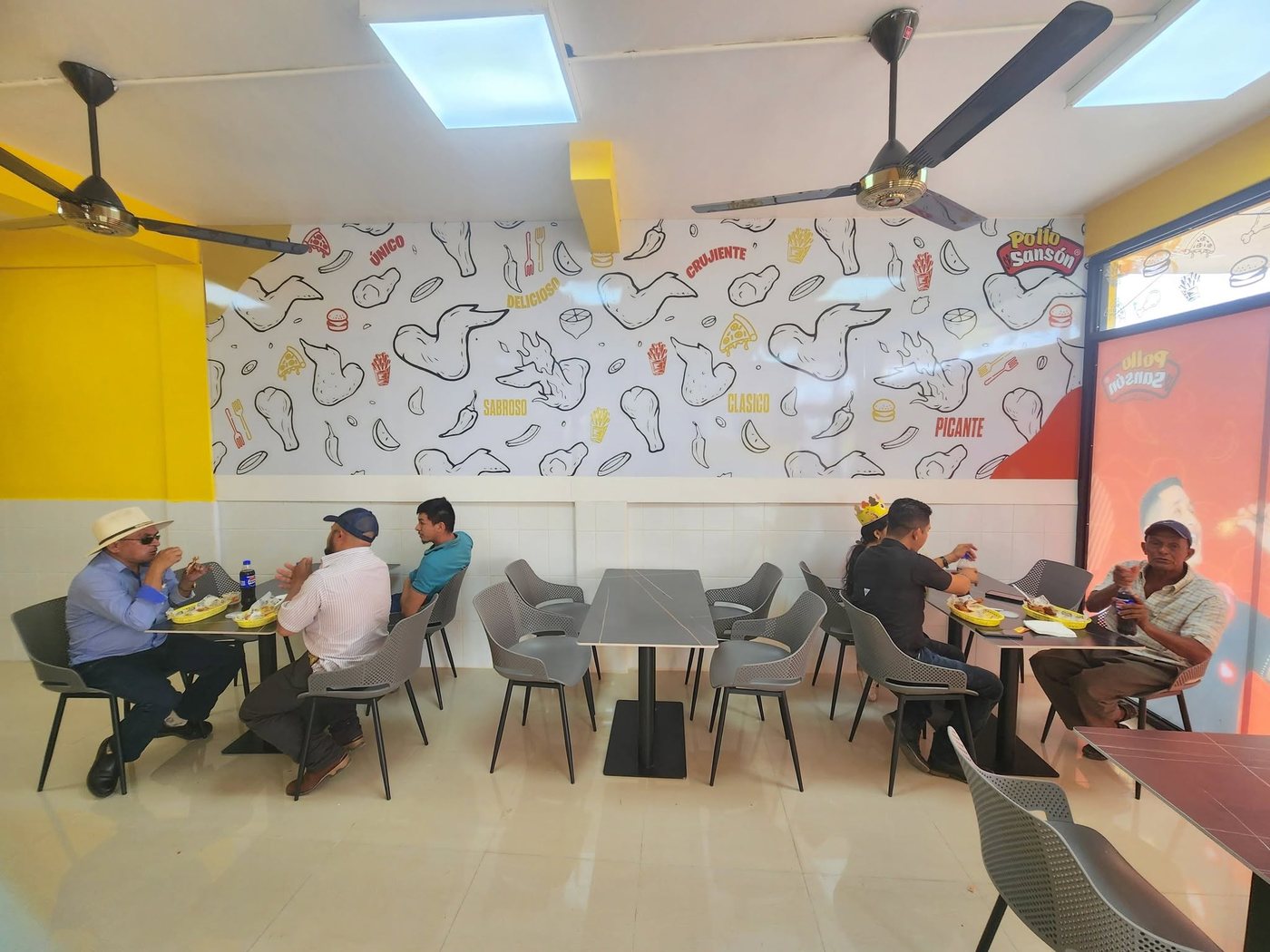 Clientes comiendo dentro de una sucursal Pollo Sansón